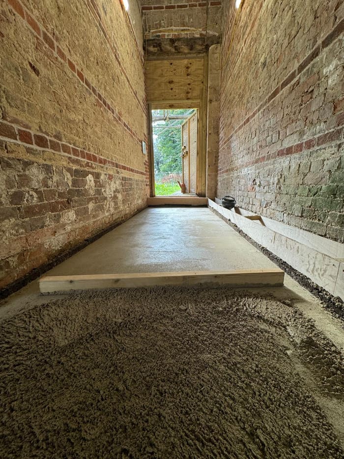 Limecrete edge and threshold detail against brick and timber